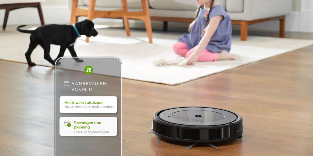 Een Roomba met een meisje en een verharende hond