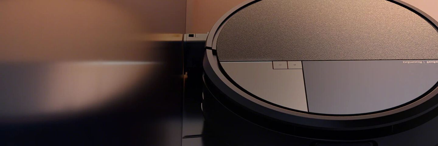 Een afbeelding van een Roomba robotstofzuiger tegen een warme, bruine achtergrond